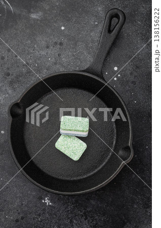 Cleaning detergent tablets in frying pan on black stone backdrop representing household cleaning and grease removal idea Cleaning detergent tablets in frying pan on black stone backdrop representing household cleaning and grease removal idea 138156222