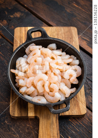 Cooked mini prawns in rustic skillet, salad shrimp portion on wooden surface, healthy protein seafood for catering and restaurant concept.. Cooked mini prawns in rustic skillet, salad shrimp portion on wooden surface, healthy protein seafood for catering and restaurant concept.. 138156228