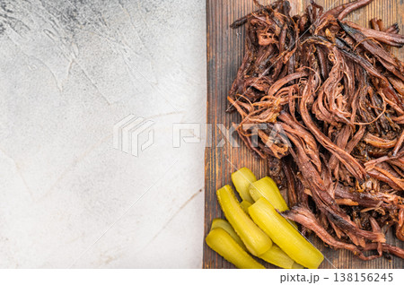 Slow cooked shredded beef brisket, smoky barbecue meat ready to serve, comfort food platter with sauce and pickles. Slow cooked shredded beef brisket, smoky barbecue meat ready to serve, comfort food platter with sauce and pickles. 138156245
