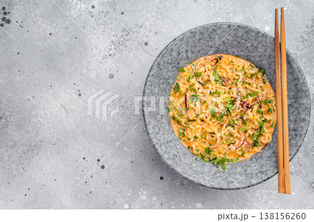 Homemade ramen noodle soup garnished with herbs and sesame served in ceramic bowl with chopsticks minimal flat lay Homemade ramen noodle soup garnished with herbs and sesame served in ceramic bowl with chopsticks minimal flat lay 138156260