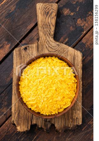 Grated cheddar cheese in bowl over wooden cutting board dark rustic table food ingredient with copy space for menu design Grated cheddar cheese in bowl over wooden cutting board dark rustic table food ingredient with copy space for menu design 138156299