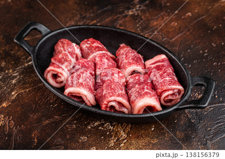 Raw marbled beef slices in cast iron pan, premium angus meat prepared for BBQ, skewers or stew cooking on rustic background 138156379