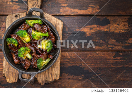Beef and broccoli stir fry cooked in wok style sauce served in small skillet on wooden background Beef and broccoli stir fry cooked in wok style sauce served in small skillet on wooden background 138156402