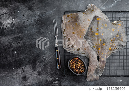 Raw flounder flatfish with spotted skin on rack with pepper on dark background fresh seafood ingredient 138156403