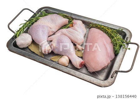 Raw chicken cuts: breast, wing, drumstick, and leg quarter, displayed on a rustic metal tray on a white surface. High-protein meat. Raw chicken cuts: breast, wing, drumstick, and leg quarter, displayed on a rustic metal tray on a white surface. High-protein meat. 138156440