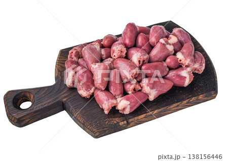 Fresh uncooked chicken hearts arranged on rustic dark wood board, close up of raw poultry meat for gourmet preparation. Fresh uncooked chicken hearts arranged on rustic dark wood board, close up of raw poultry meat for gourmet preparation. 138156446