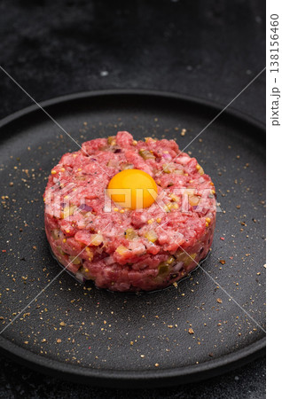 Beef tartare with yolk on black dish against dark backdrop great for gourmet cooking protein rich meals and high quality food photography. 138156460