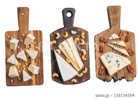 Selection of creamy Camembert soft Brie and bold Roquefort arranged with cashews pine nuts and pecans over wooden boards. Selection of creamy Camembert soft Brie and bold Roquefort arranged with cashews pine nuts and pecans over wooden boards. 138156504