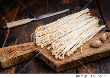 Fresh raw Enoki mushrooms (Flammulina filiformis) in a black plastic retail container on a clean white background. Ready for sale. Fresh raw Enoki mushrooms (Flammulina filiformis) in a black plastic retail container on a clean white background. Ready for sale. 138156537