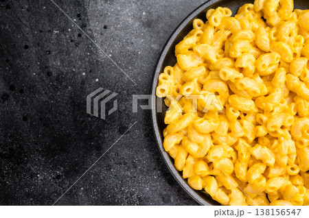 Golden mac and cheese in a black skillet, rustic dark background, fork beside Golden mac and cheese in a black skillet, rustic dark background, fork beside 138156547