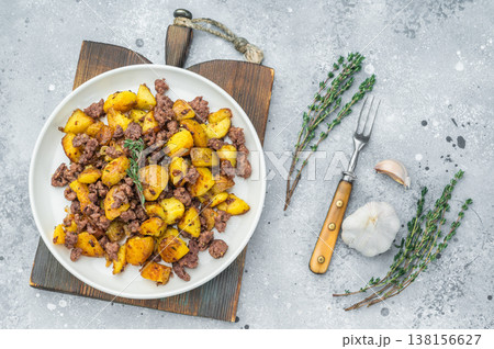 Skillet style beef hash, Golden roasted potatoes mixed with minced meat, top view on white plate. Skillet style beef hash, Golden roasted potatoes mixed with minced meat, top view on white plate. 138156627