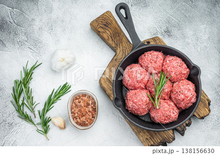 Raw kofta style meatballs seasoned in skillet over rustic board ideal for culinary, kitchen and ingredient stock photography. Raw kofta style meatballs seasoned in skillet over rustic board ideal for culinary, kitchen and ingredient stock photography. 138156630