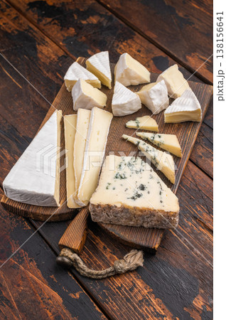 Selection of creamy Brie soft Camembert and blue Roquefort displayed on a textured wooden board for an artisanal gourmet look. Selection of creamy Brie soft Camembert and blue Roquefort displayed on a textured wooden board for an artisanal gourmet look. 138156641