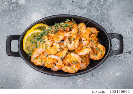 Homemade Garlic Butter Shrimp Scampi served hot in a small skillet, garnished with fresh thyme and a side of pink salt. Rustic kitchen style. 138156696