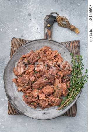 Hearty braised moose venison stew on a grey background, tender shredded game meat cooked slow for deep savory taste and rustic appeal. Hearty braised moose venison stew on a grey background, tender shredded game meat cooked slow for deep savory taste and rustic appeal. 138156697