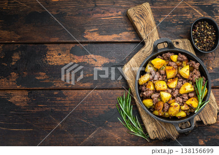 Classic skillet style beef hash inspired by Pyttipanna with golden potatoes and herbs on a textured wooden surface. Classic skillet style beef hash inspired by Pyttipanna with golden potatoes and herbs on a textured wooden surface. 138156699