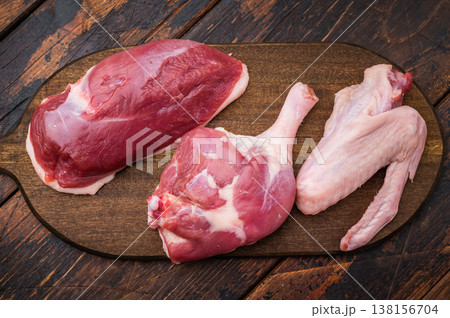 Raw Duck parts breast wing and thigh with herbs on vintage wooden background great for culinary styling butcher content and stock photography. 138156704