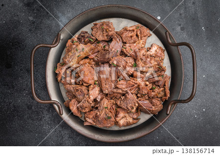 Slowcooked wild venison moose meat, tender and juicy, served with rosemary on rustic metal plate against dark textured stone surface Slowcooked wild venison moose meat, tender and juicy, served with rosemary on rustic metal plate against dark textured stone surface 138156714