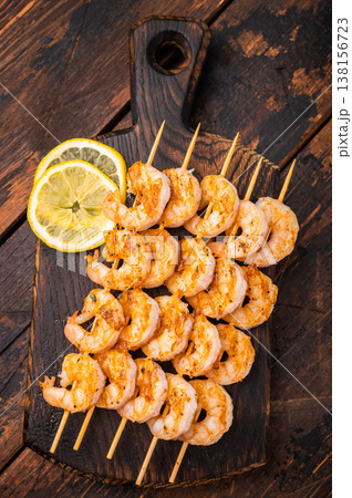 Gourmet seafood appetizer: spiced prawn shrimp kebabs served on a weathered dark wood table. Perfect for menus and recipe books. Gourmet seafood appetizer: spiced prawn shrimp kebabs served on a weathered dark wood table. Perfect for menus and recipe books. 138156723