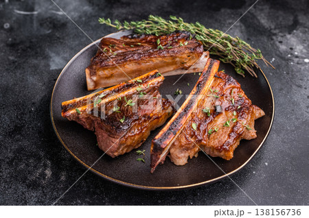 Gourmet glazed beef short ribs with fresh rosemary. Deep rusty brown background with ample negative space. 138156736