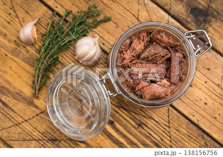 Rustic venison preserved stew in a glass jar with garlic, thyme and pepper on a wooden board. Hearty wildgame meat with rich slowcooked flavor. 138156756