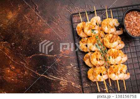 Grilled shrimp prawn skewers on a dark rustic background. Delicious seafood kebab, perfect for a gourmet appetizer or dinner menu. Grilled shrimp prawn skewers on a dark rustic background. Delicious seafood kebab, perfect for a gourmet appetizer or dinner menu. 138156758
