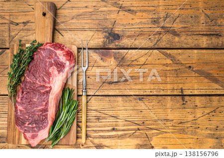 Uncooked sirloin steak with herbs on rustic wood excellent for gourmet cuisine barbecue concepts butcher promos and kitchen preparation scenes. Uncooked sirloin steak with herbs on rustic wood excellent for gourmet cuisine barbecue concepts butcher promos and kitchen preparation scenes. 138156796