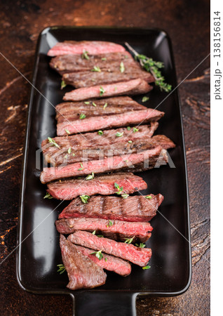 Sliced grilled beef steak served on black plate, juicy medium rare meat with clean presentation and copy space, gourmet restaurant style Sliced grilled beef steak served on black plate, juicy medium rare meat with clean presentation and copy space, gourmet restaurant style 138156814