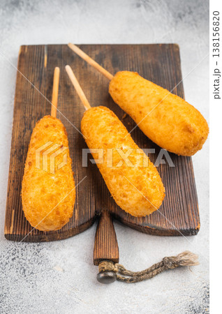Fried corndogs with crispy coating and sauces on wooden board, street food snack on light background, top view 138156820