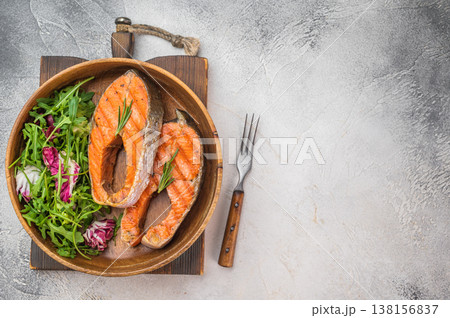 Grilled salmon steaks also known as red fish served in wooden bowl with fresh salad, light background with copy space Grilled salmon steaks also known as red fish served in wooden bowl with fresh salad, light background with copy space 138156837