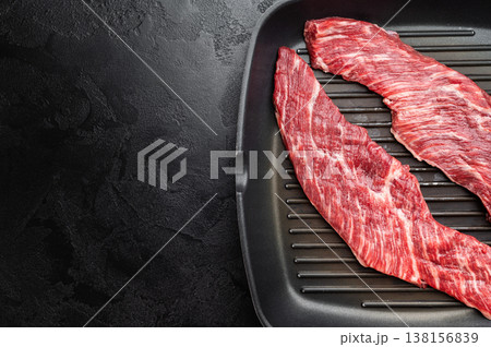 Closeup raw beef premium steak on grill pan showing texture and grain, uncooked meat ready for searing grilling or barbecue cooking Closeup raw beef premium steak on grill pan showing texture and grain, uncooked meat ready for searing grilling or barbecue cooking 138156839