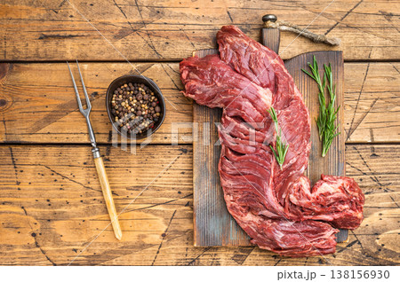 Butcher style raw beef diaphragm hanger steak on cutting board, natural wood table background with copy space, perfect for cooking and bbq themes Butcher style raw beef diaphragm hanger steak on cutting board, natural wood table background with copy space, perfect for cooking and bbq themes 138156930