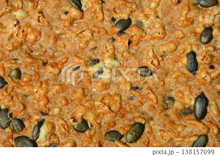Texture of a cracker with pumpkin seeds and melted cheese Texture of a cracker with pumpkin seeds and melted cheese 138157099