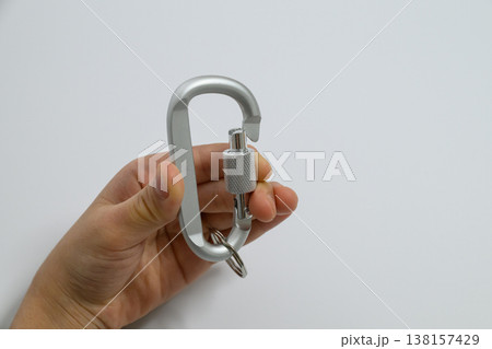 手に持つシルバーのカラビナと広い白背景 138157429