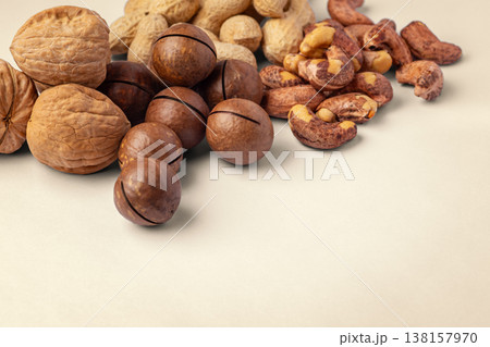 Mixed nuts with nutshell, walnut, macadamia, cashew, peanuts on brown background 138157970