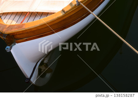 Old wooden moored boat in the clear dark water Old wooden moored boat in the clear dark water 138158287