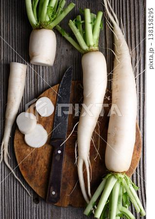 Sliced daikon radish with knife on rustic board 138158295