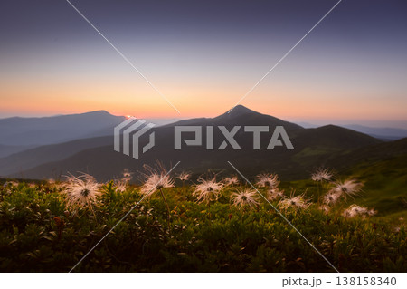 Sunset over mountain silhouettes with soft gradient sky and glowing horizon Sunset over mountain silhouettes with soft gradient sky and glowing horizon 138158340