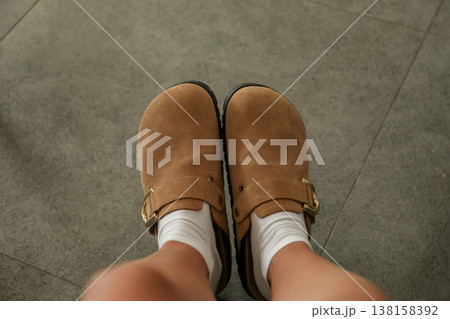 Person is wearing brown shoes with white socks indoors 138158392