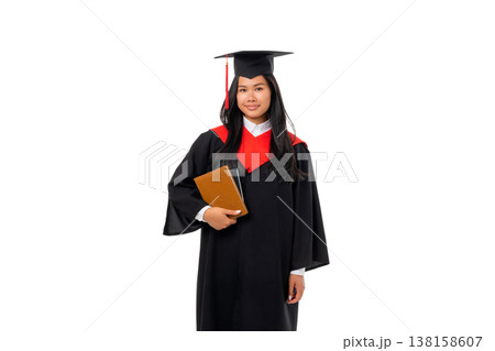 Woman in graduation attire holding a book and smiling, isolated, PNG 138158607