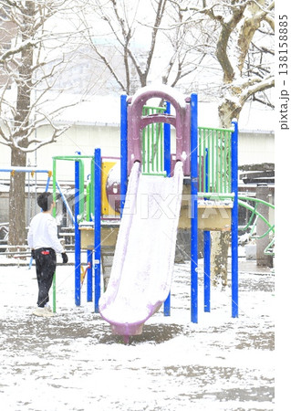 雪の降る日の公園と遊具で遊ぶ子供 雪の降る日の公園と遊具で遊ぶ子供 138158885