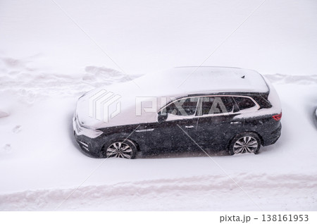 Snow-covered car during heavy winter snowfall on city street Snow-covered car during heavy winter snowfall on city street 138161953