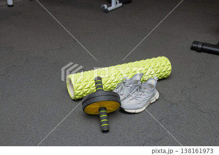 Foam roller and ab wheel with sneakers on gym floor Foam roller and ab wheel with sneakers on gym floor 138161973