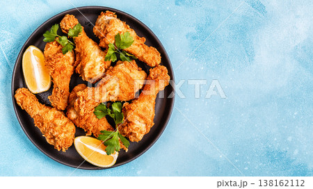 Fried chicken legs with lemon and parsley. 138162112