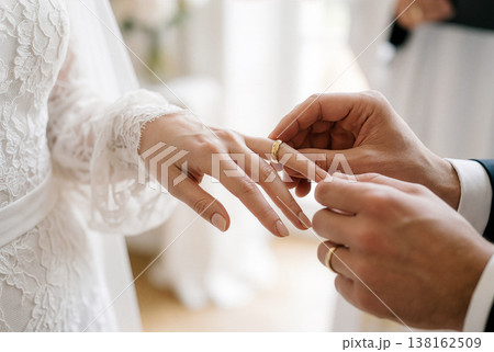結婚指輪を交換するカップルの手のクローズアップ 138162509