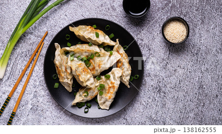 Fried dumplings Gyoza on a plate on a gray concrete background Fried dumplings Gyoza on a plate on a gray concrete background 138162555