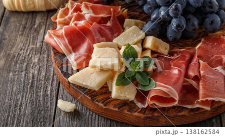 Prosciutto, wine, grape, parmesan on wooden table. Prosciutto, wine, grape, parmesan on wooden table. 138162584