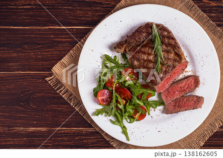 Ribeye steak with arugula and tomatoes. Ribeye steak with arugula and tomatoes. 138162605