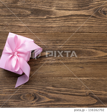Pink gift box on rustic wooden background Pink gift box on rustic wooden background 138162702