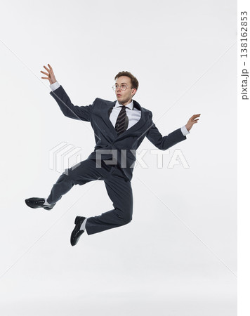 Businessman jumping mid air in expressive pose isolated on white background. Businessman jumping mid air in expressive pose isolated on white background. 138162853